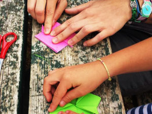 bambini fanno origami sul tavolo nello spazio gioco
